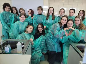 Zdjęcie zbiorowe uczniów w fartuchach laboratoryjnych.