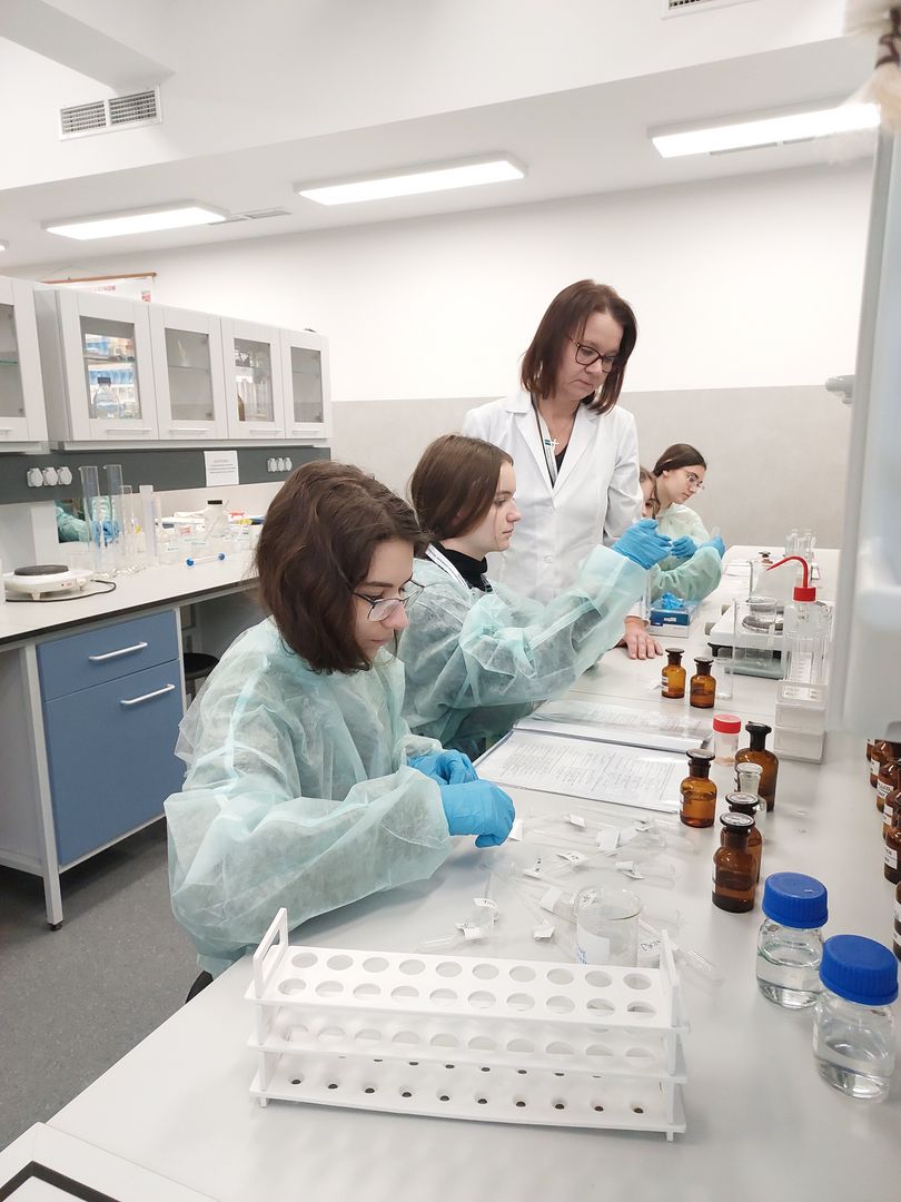 W laboratorium chemicznym uczennice próbujące zidentyfikować kation zawarty w zadanej próbce.