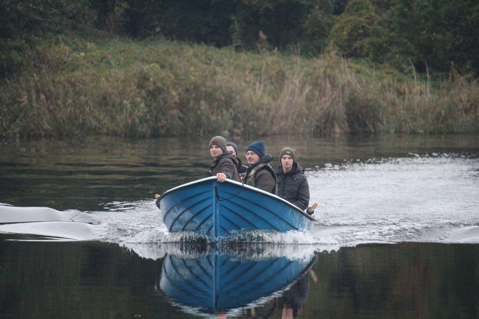 Studencji płyną łodzią przez jezioro.