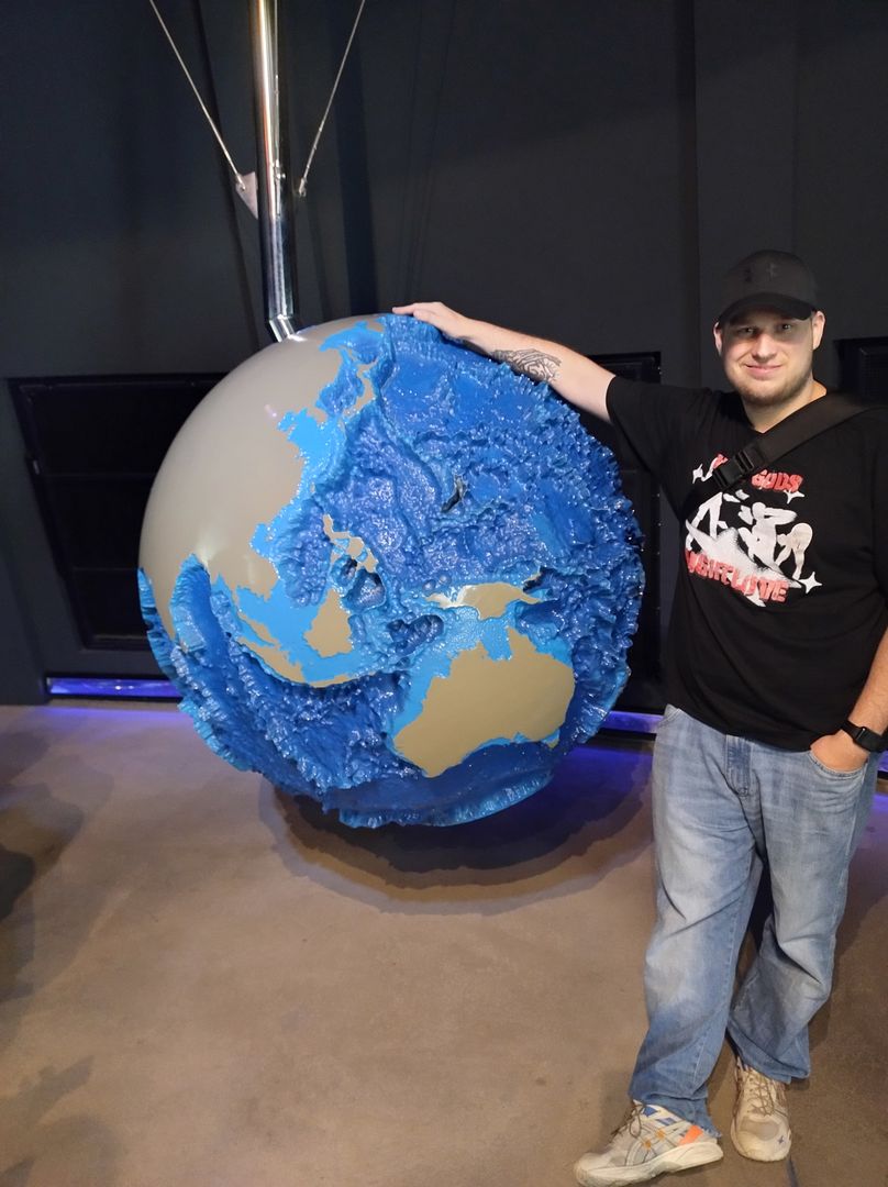 Student Szymon Syryjski-Giro i model ziemi wraz ze strukturą dna mórz i oceanów