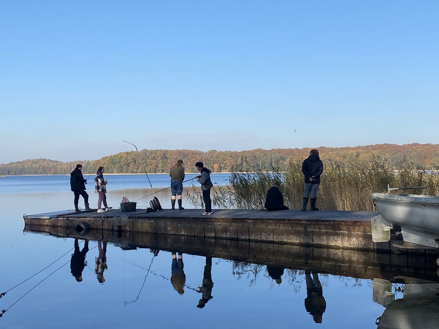 Studenci poławiają z pomostu ryby do badań.